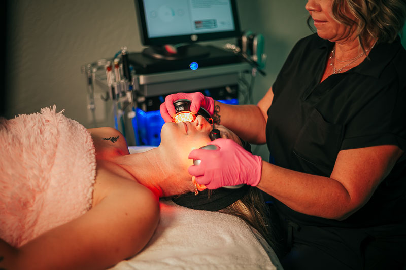 Client receiving a rejuvenating oil treatment at Pura Vida Skin Studio